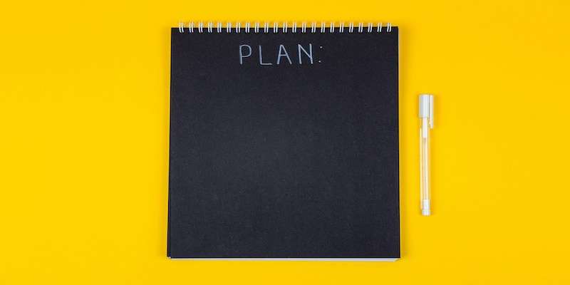 black slate with the word plan in front of yellow background