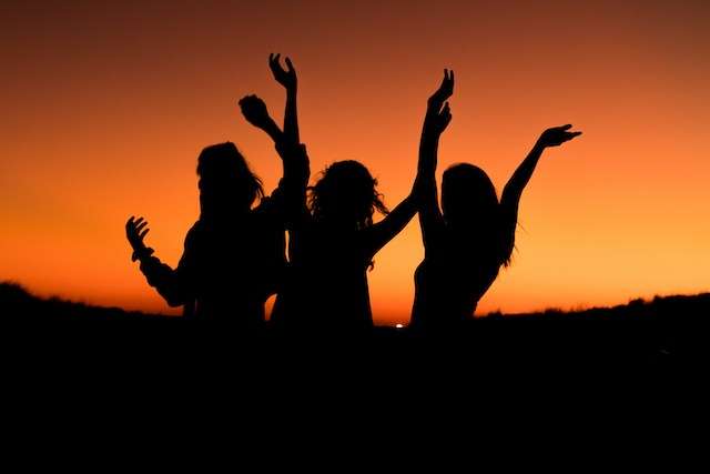 three female silhouettes at sunset at outdoor corporate event